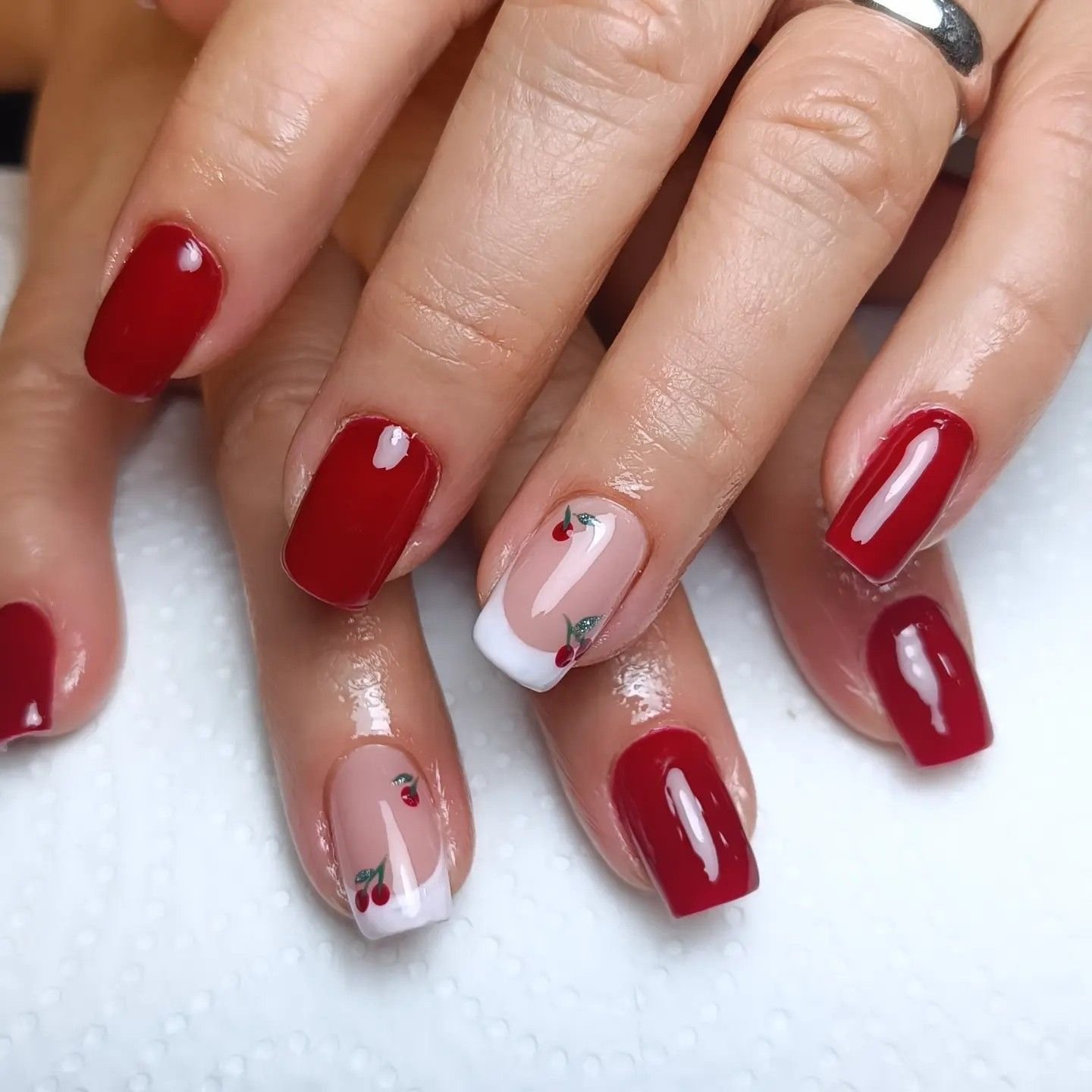 Manicura semipermanente roja con francesa de cerezas en Córdoba